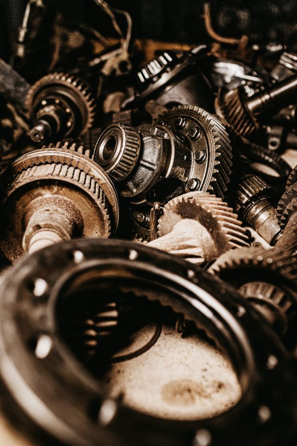 A vertical shot of grey, metallic gears, and car parts